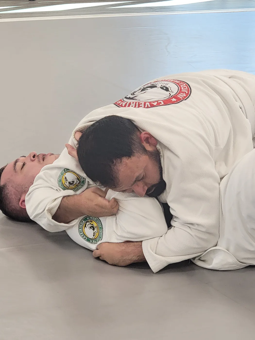 Adult Jiu-Jitsu class at CJJF Las Vegas — coach instructing students in CJJF gis on the mat