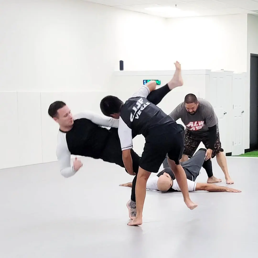 Adults practicing a No-Gi throw at CJJF