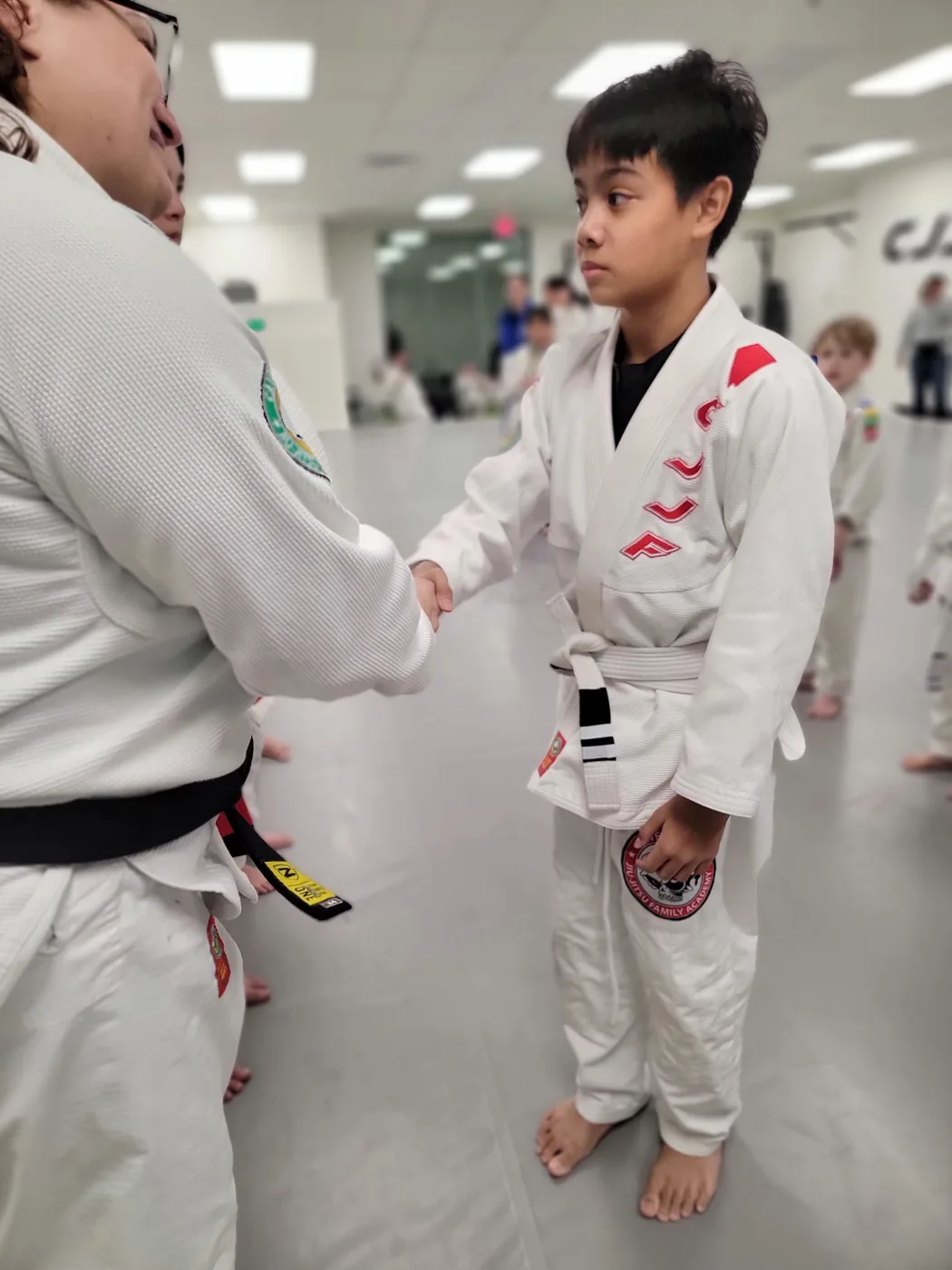Teen student shaking hands with coach at CJJF Las Vegas Teens Jiu-Jitsu class